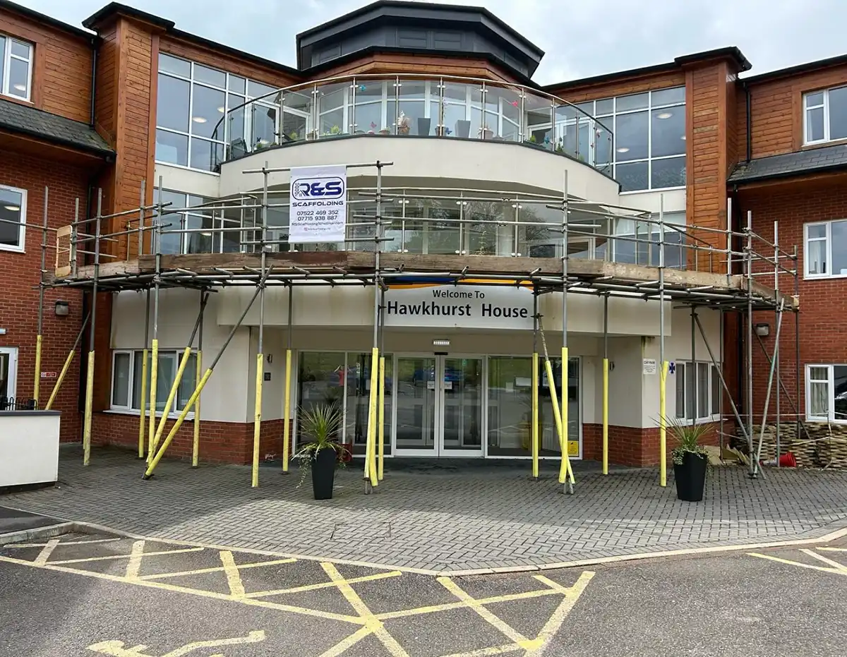 Entrance of Hawkhurst House with scaffolding and safety poles around the doorway.